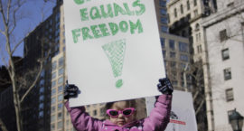 a little girl holds up a sign reading CHOICE EQUALS FREEDOM! at a women's march