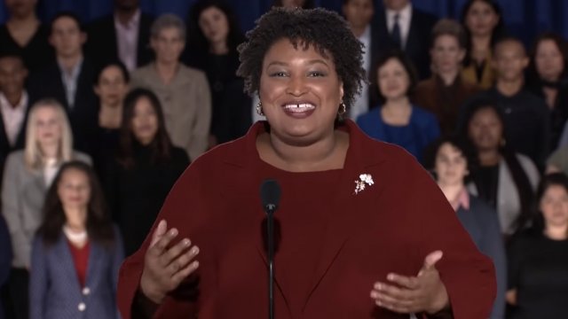 stacey abrams speaking in a red suit