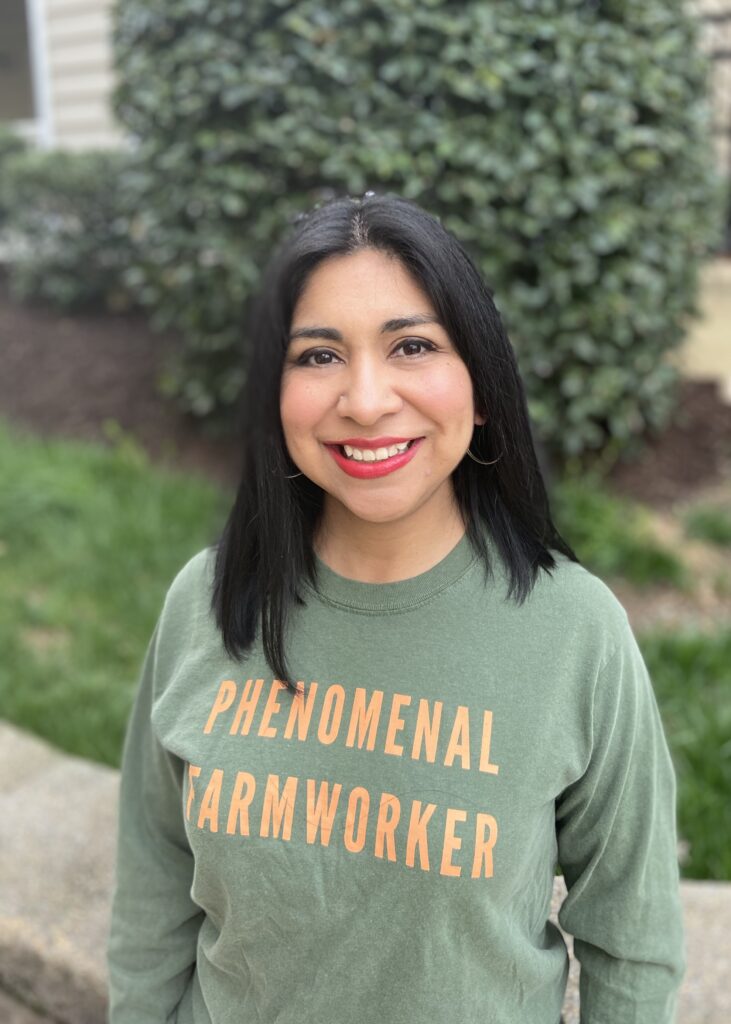 Labor rights activist Norma Flores López standing with "Phenomenal Farmworker" shirt.