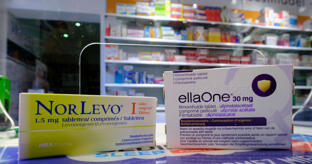 A yellow box of Norlevo 1.5mg, a medication typically used for emergency contraception from HRA Pharma, and a purple box of EllaOne (ulipristal acetate 30mg) side by side at a pharmacy