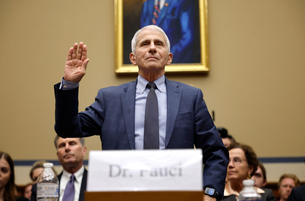 Dr. Anthony Fauci lifts his hand to swear in before testifying about COVID-19