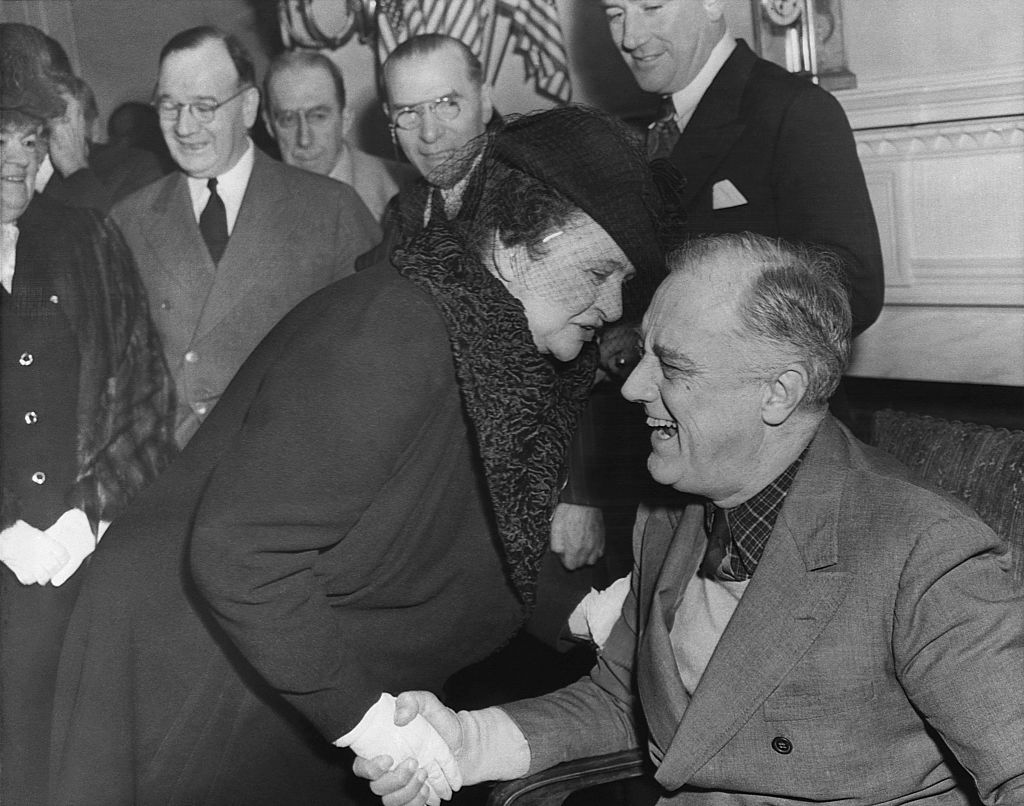 Frances Perkins shakes hands with President Franklin D. Roosevelt with the rest of his Cabinet.