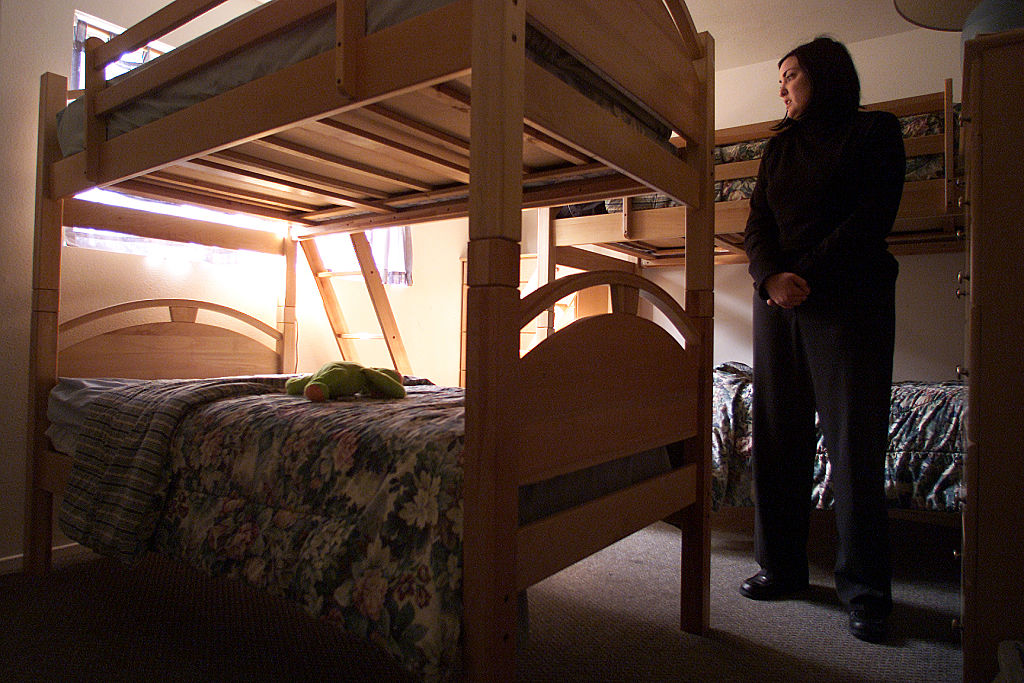 Summer Loree, shelter manager for The Coalition to end Domestic and Sexual Violence, stands in a bedroom crammed with bunk beds in the Ventura area shelter