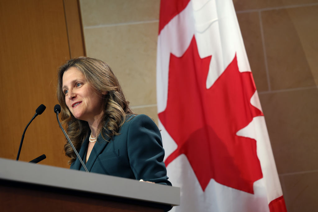 Chrystia Freeland speaks in front of a Canadian flag