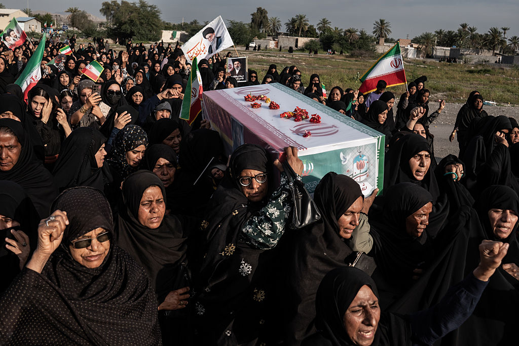 People are seen carrying a coffin