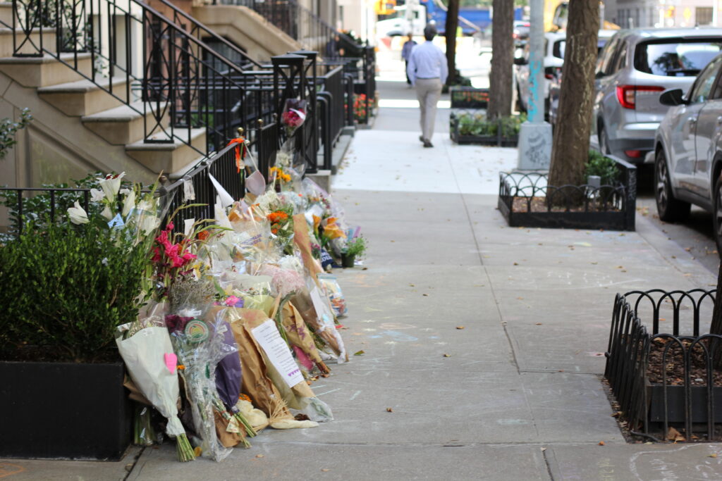 Bouquets of flowers lay on the sidewalk outside Gloria Steinem's apartment after her death. 