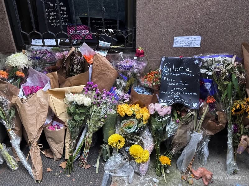 Bouquets of flowers are laid on the ground outside Gloria Steinem's apartment after her death. 