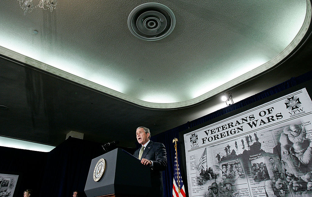 Then-President George W. Bush stands on a podium and speaks about the war in Iraq.
