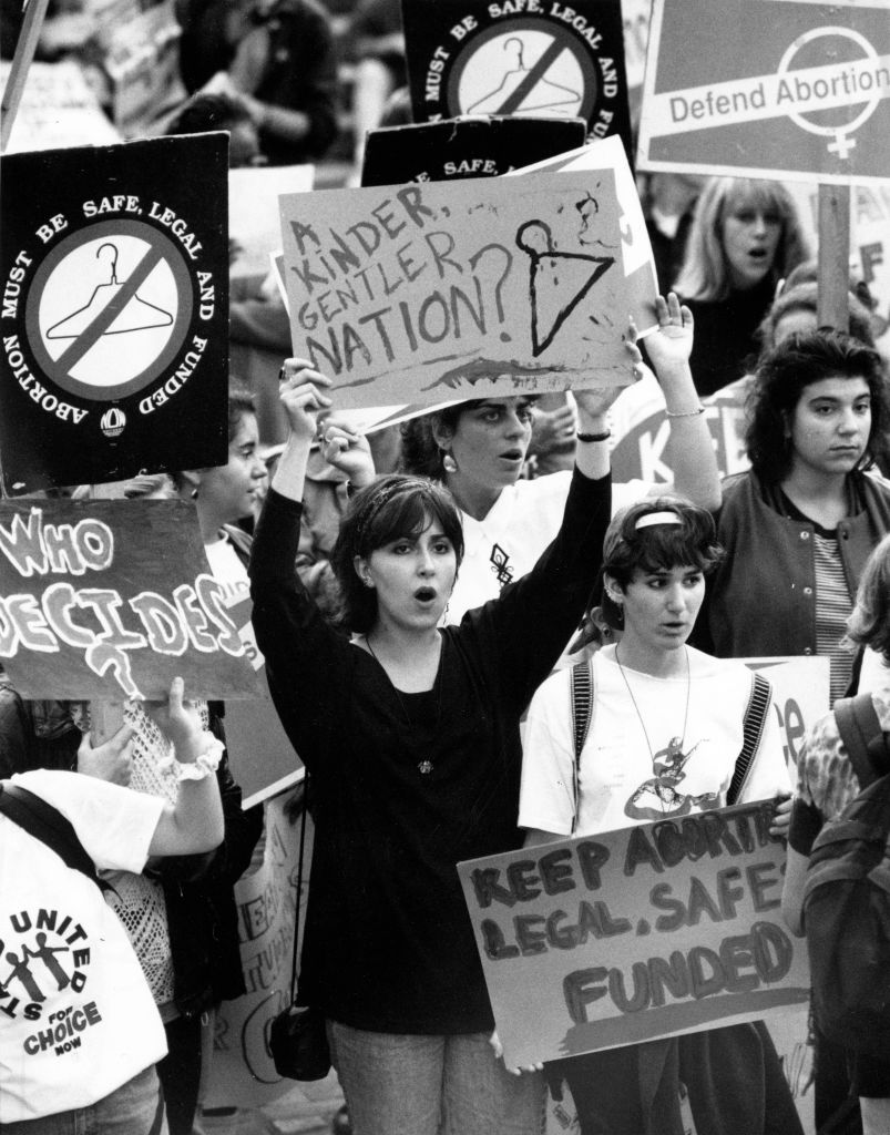 A black and white photograph at an abortion rights demonstration in 1991 displays people holding signs.