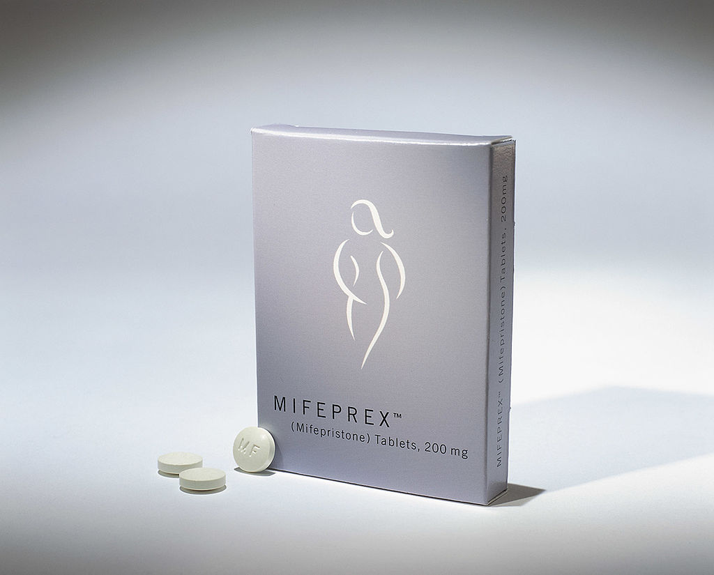 A gray box of Mifeprex mifepristone tablets has the sliouhuette of a woman on it.