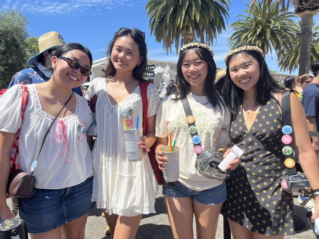 A group of four young Asian women stands together smiling.