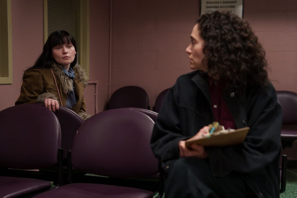 Two actresses in Hulu's furious look at each other across a set of chairs. 